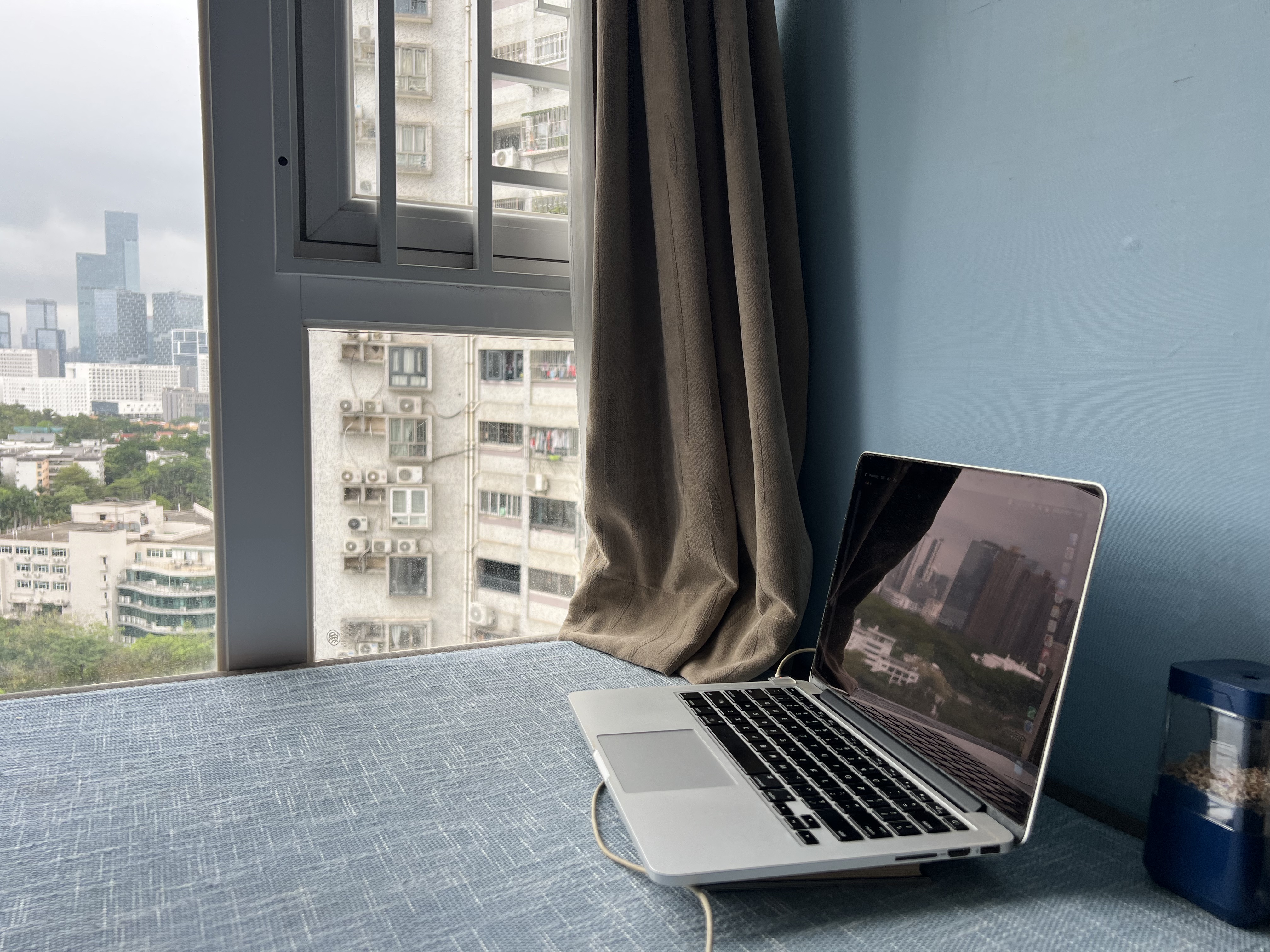 MacBook Pro on desk with skyline reflection